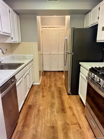 a kitchen with granite countertop a refrigerator and a stove
