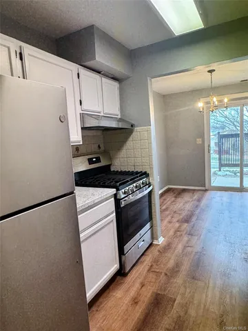 a kitchen with granite countertop a refrigerator a sink and a stove