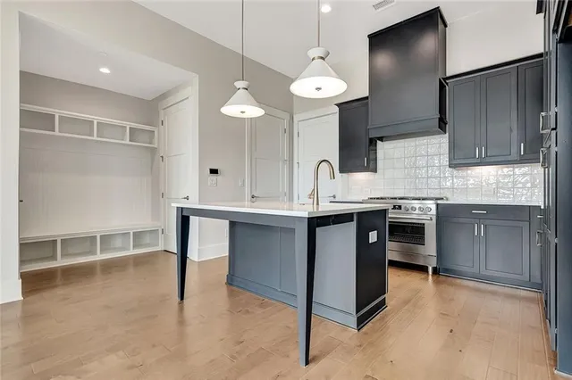 a kitchen with kitchen island a sink stainless steel appliances and cabinets