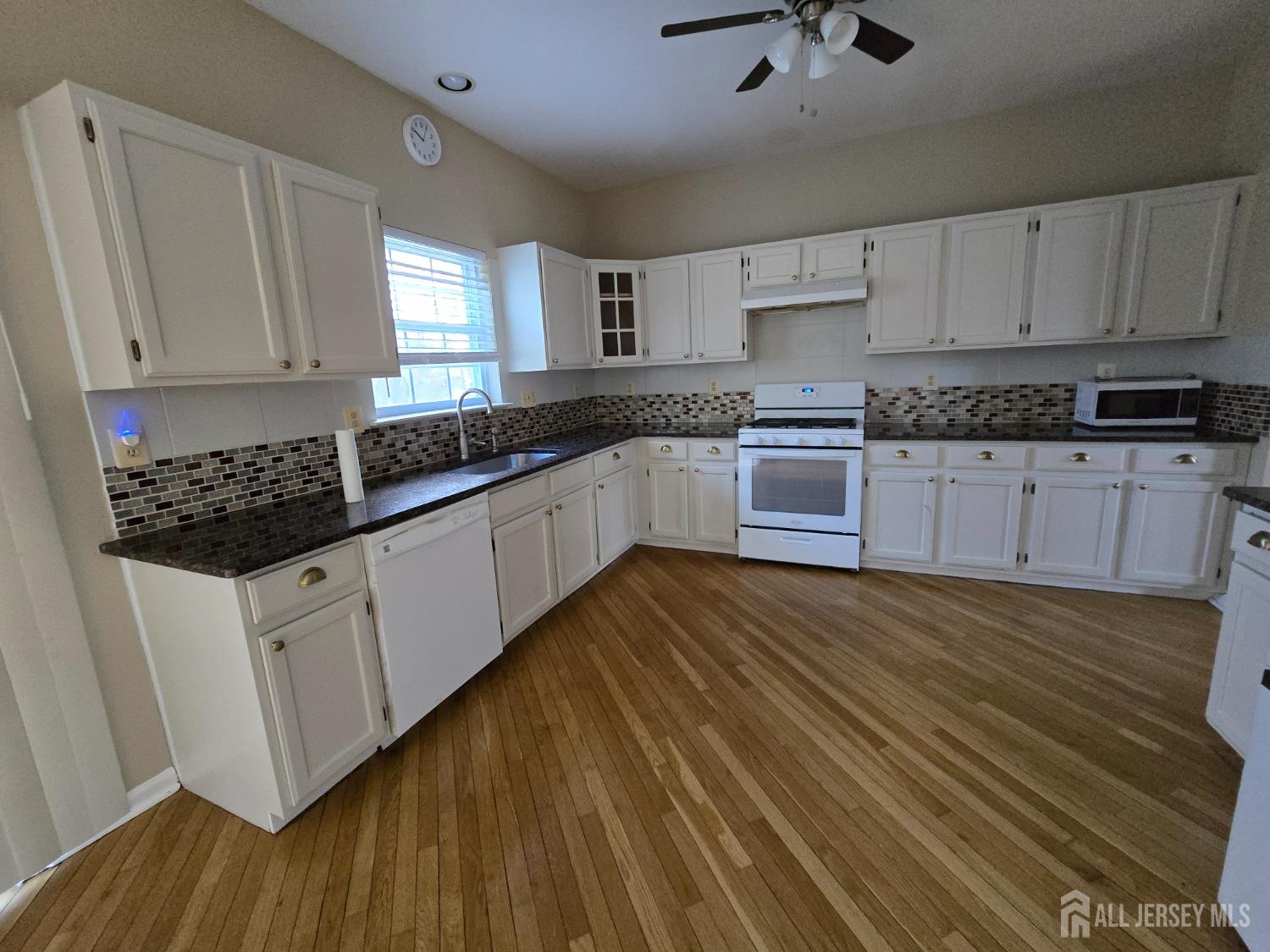 40 Potomac Road Monmouth Junction, NJ 08852 - Photo 11 of 48 a kitchen with stainless steel appliances granite countertop a stove a sink and white cabinets