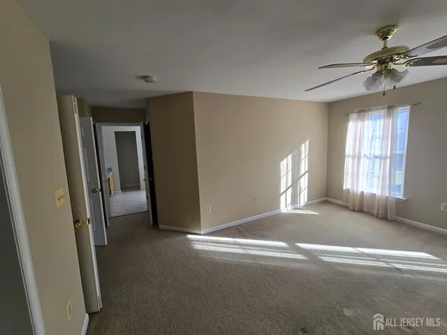 a view of a livingroom with a ceiling fan and window