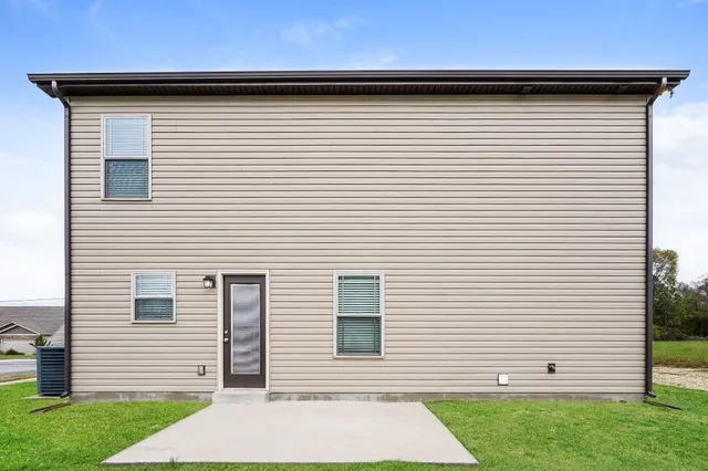 a view of a white house with a yard and garage