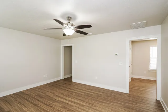 a view of an empty room with wooden floor