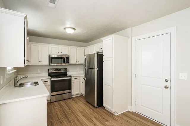 a kitchen with stainless steel appliances a refrigerator sink and stove