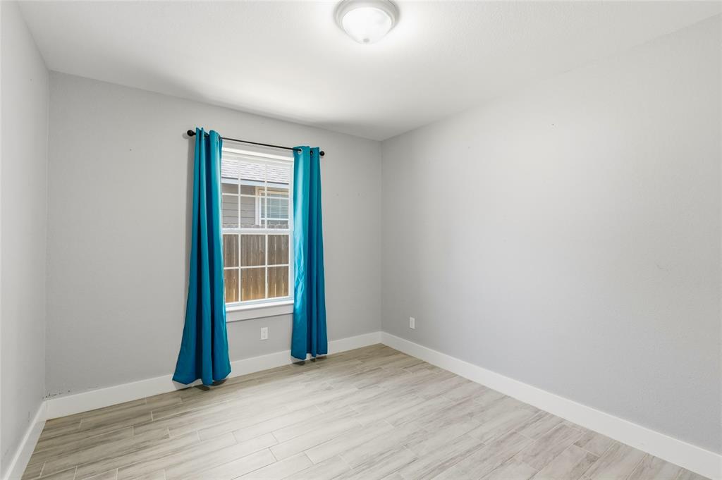 318 Munson Street Denison, TX 75021 - Photo 17 of 21 an empty room with wooden floor and windows