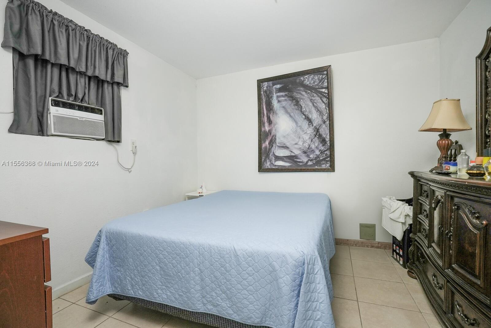 8461 Southwest 38th Street Miami, FL 33155 - Photo 15 of 27 a bedroom with a bed and a painting on the wall