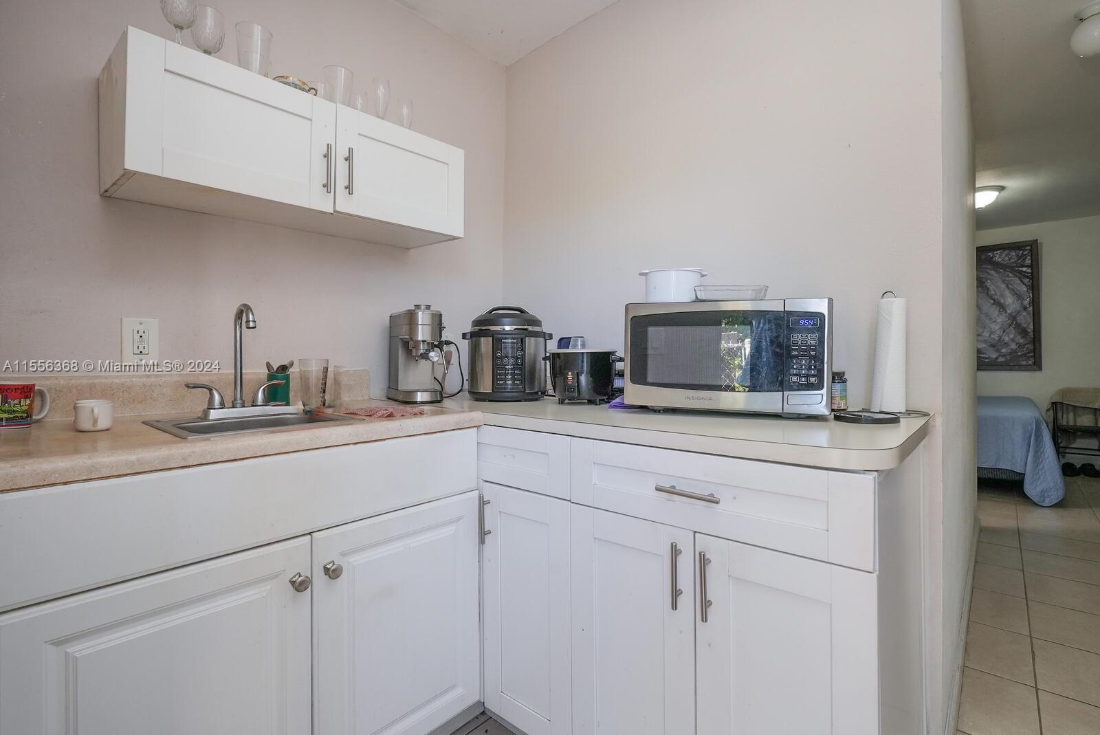 8461 Southwest 38th Street Miami, FL 33155 - Photo 19 of 27 a kitchen with cabinets appliances a sink and a counter top