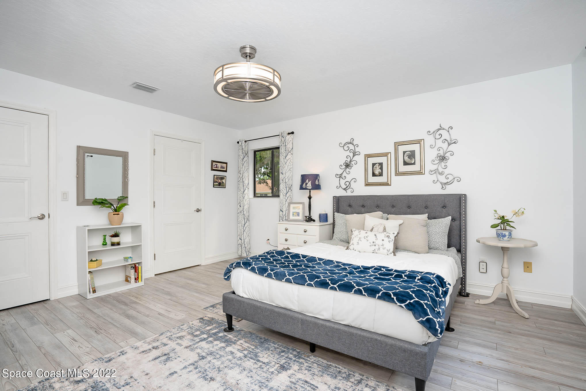 1425 Kitty Hawk Way Melbourne, FL 32940 - Photo 12 of 53 a bedroom with a large bed and a wooden floor