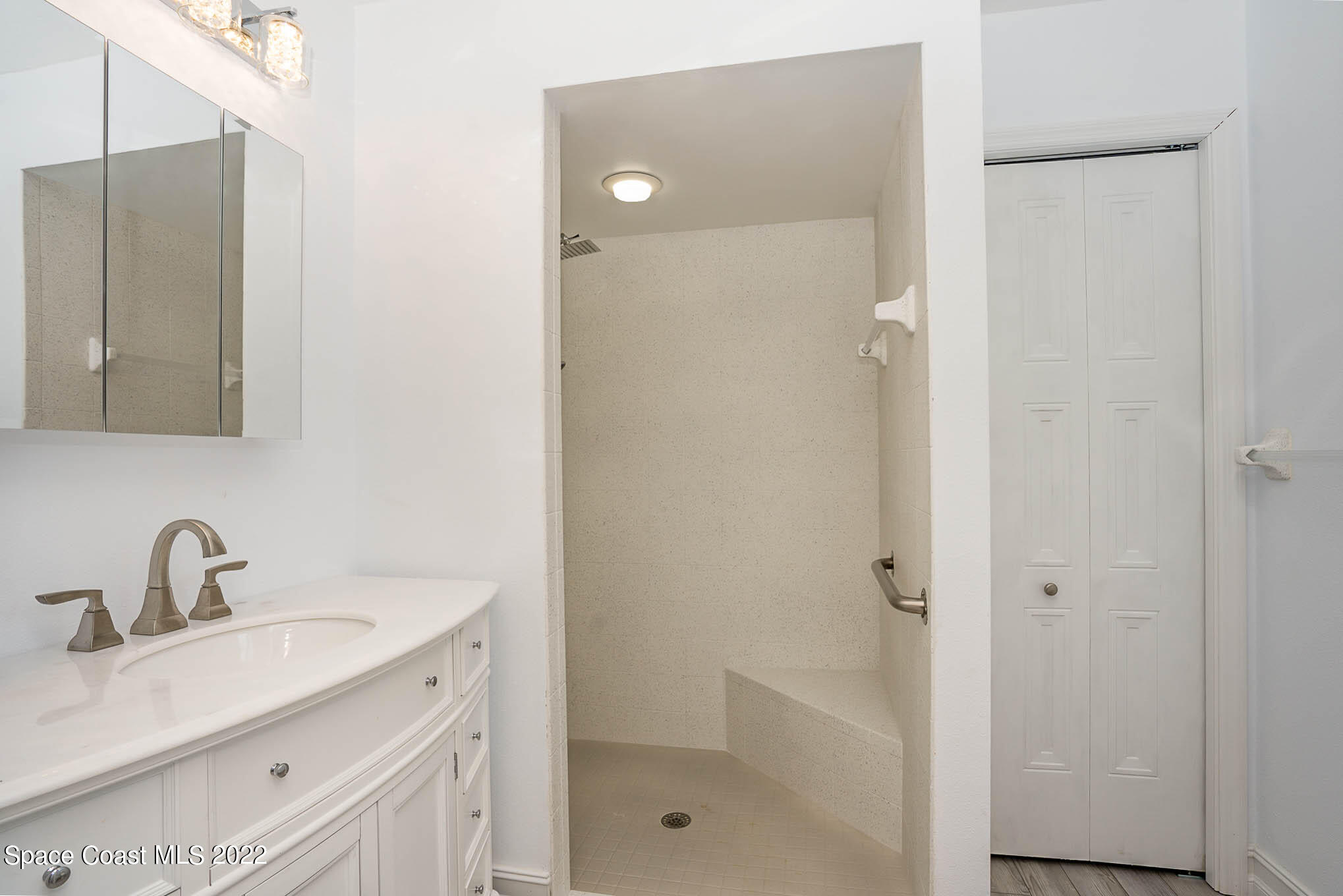 1425 Kitty Hawk Way Melbourne, FL 32940 - Photo 16 of 53 a bathroom with a shower sink vanity and mirror