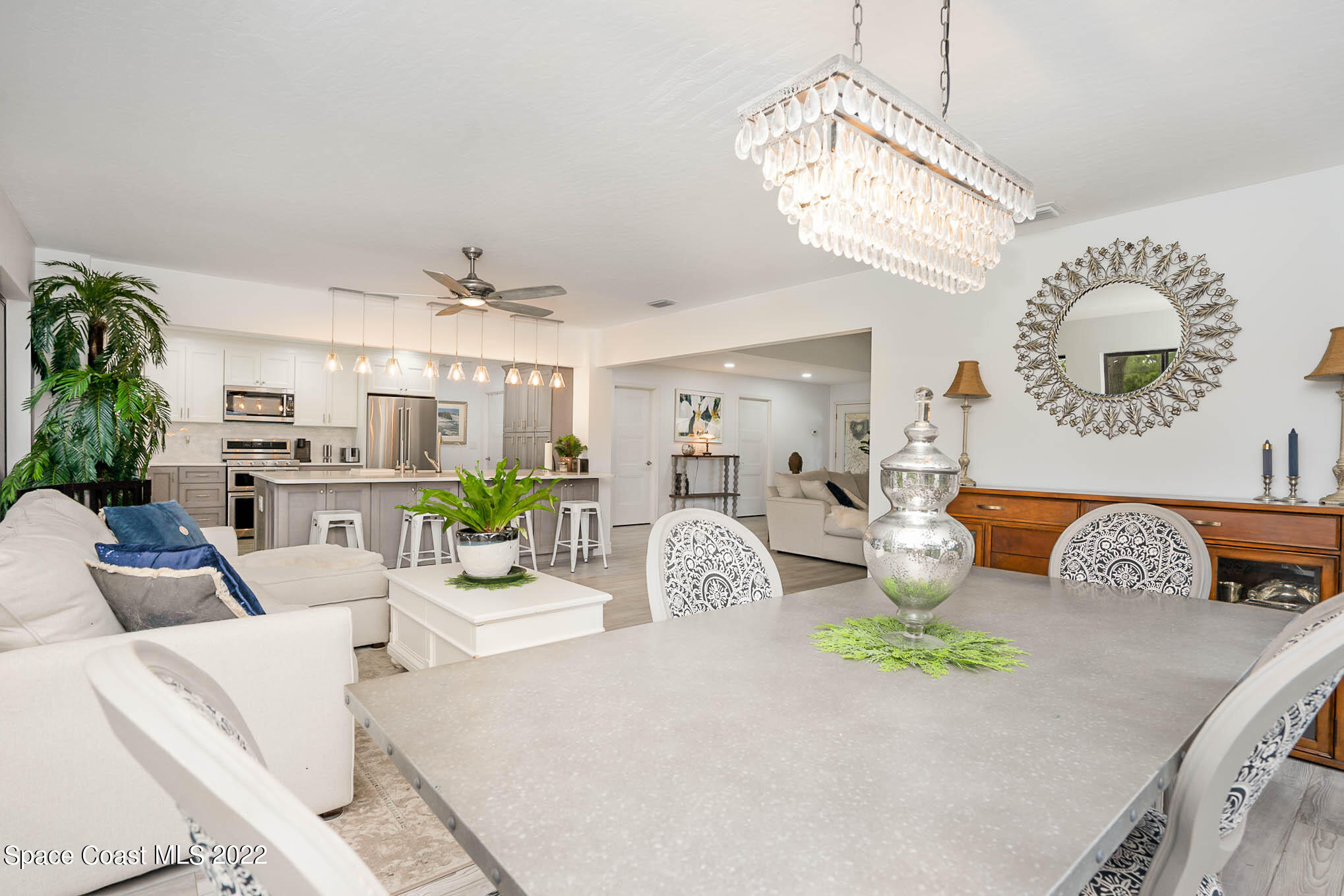 1425 Kitty Hawk Way Melbourne, FL 32940 - Photo 21 of 53 a living room with furniture chandelier and a large mirror