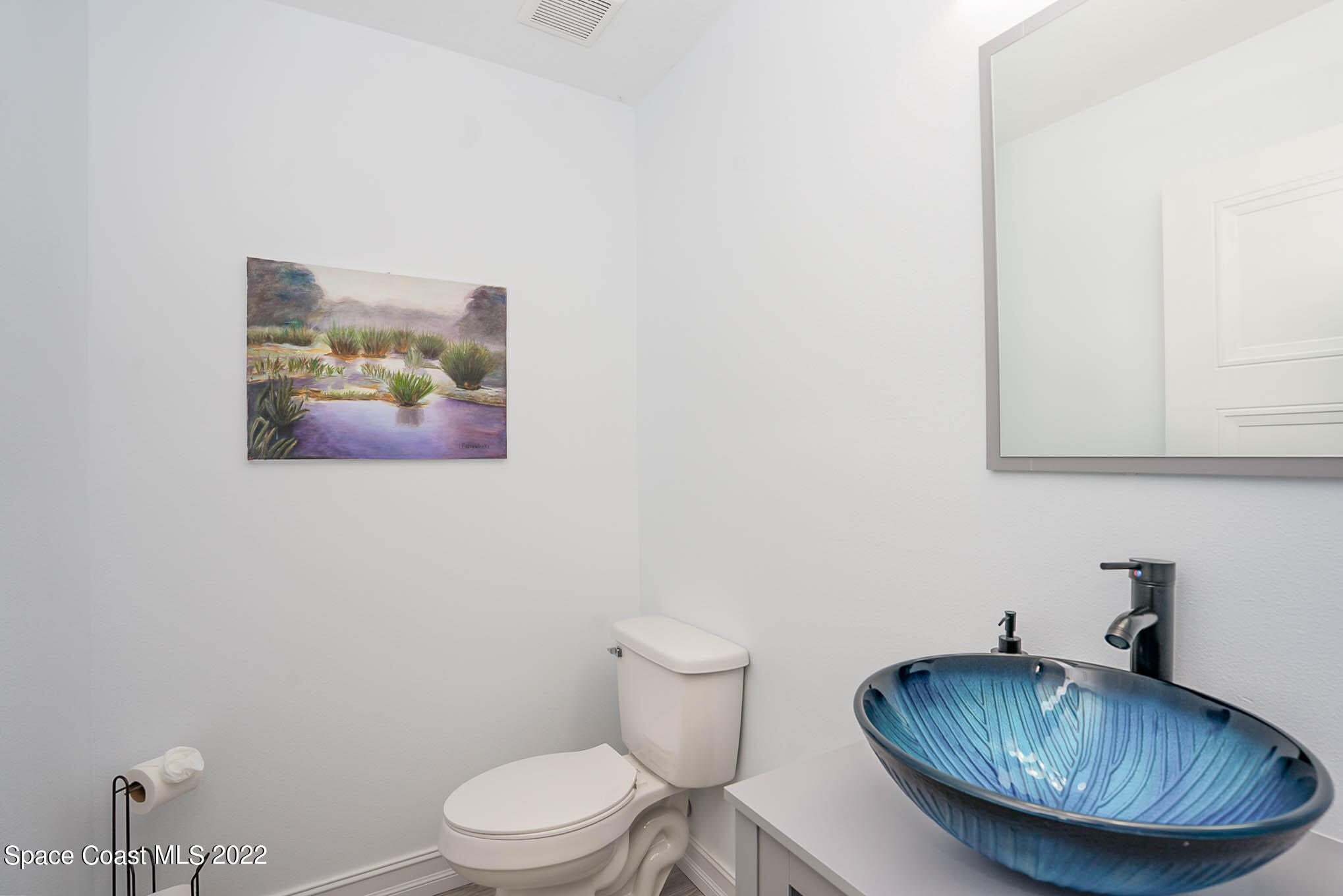 1425 Kitty Hawk Way Melbourne, FL 32940 - Photo 6 of 53 a bathroom with a granite countertop a toilet a sink and mirror