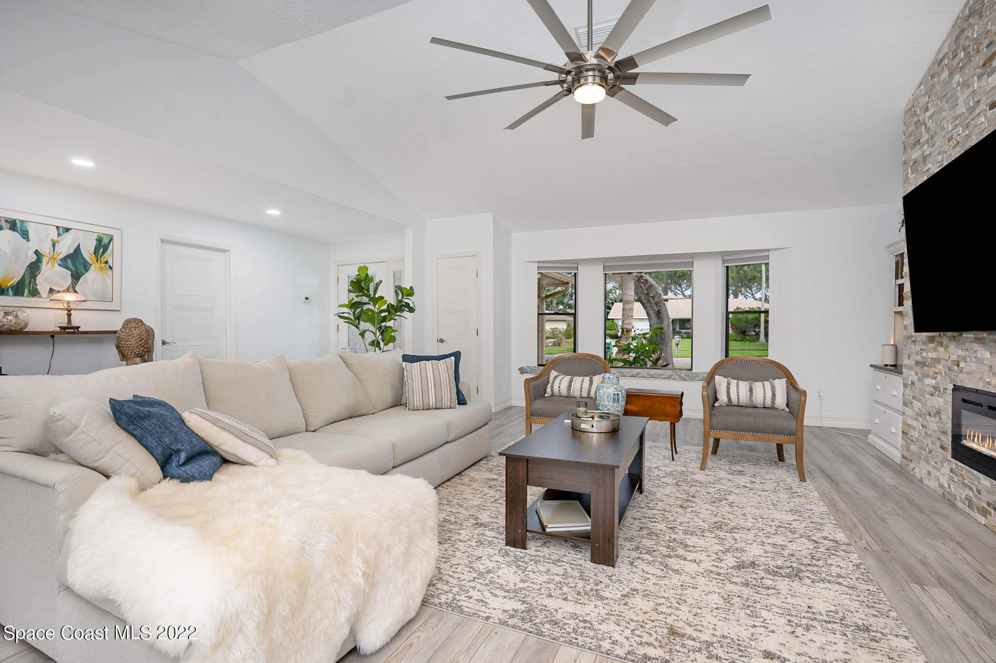 1425 Kitty Hawk Way Melbourne, FL 32940 - Photo 10 of 53 a living room with furniture a flat screen tv and a fireplace