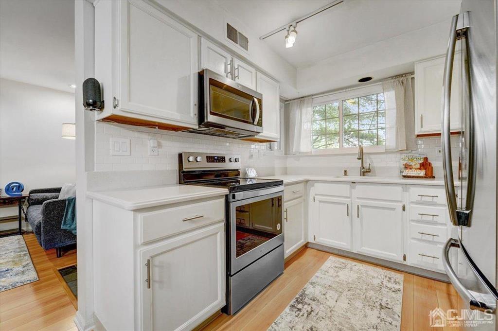 9 Tory Court Bedminster, NJ 07921 - Photo 5 of 26 a kitchen with stainless steel appliances white cabinets a sink and a stove