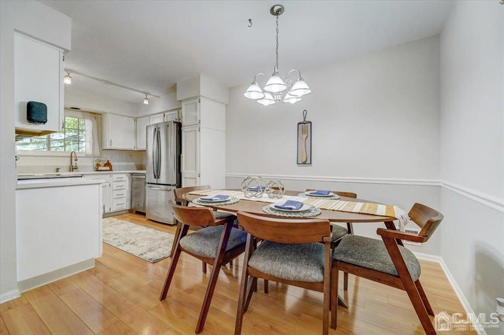 9 Tory Court Bedminster, NJ 07921 - Photo 7 of 26 a view of a dining room with furniture a chandelier and wooden floor