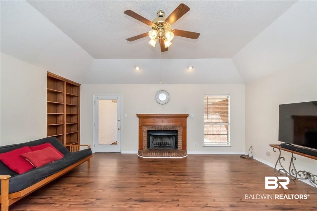 6601 Conde Court Mobile, AL 36695 - Photo 8 of 30 Living room with ceiling fan, wood-type flooring, a brick fireplace, and vaulted ceiling