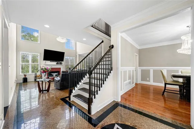 a view of a dining room with furniture a chandelier and wooden floor