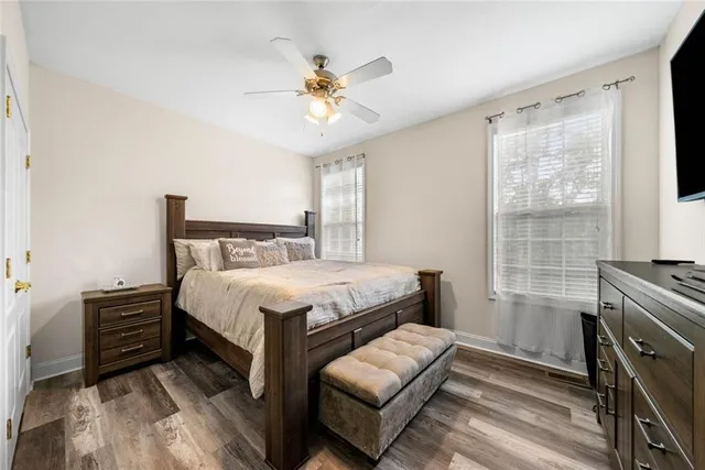 a view of a dining room and livingroom with furniture wooden floor a rug a painting and a chandelier