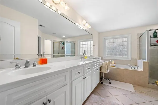 a bathroom with a tub sink and mirror