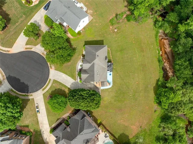 an aerial view of a house with a yard and trees