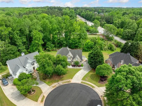 an aerial view of a house with a yard and trees