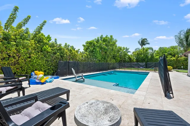 a view of a backyard with swimming pool and furniture