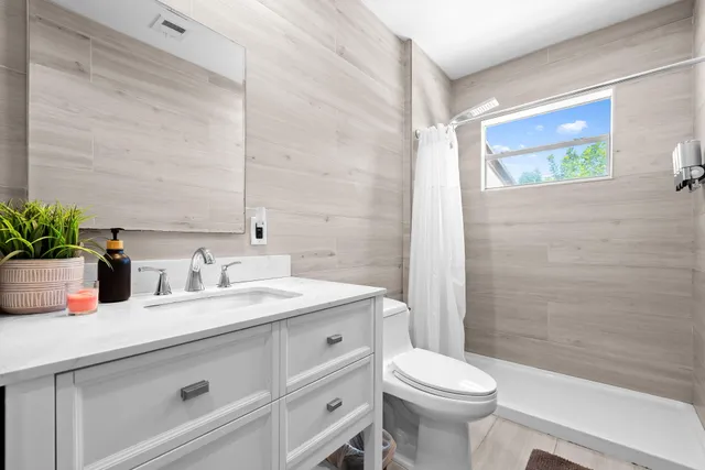 a bathroom with a sink a toilet and shower