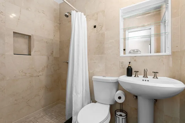 a bathroom with a sink a toilet and shower