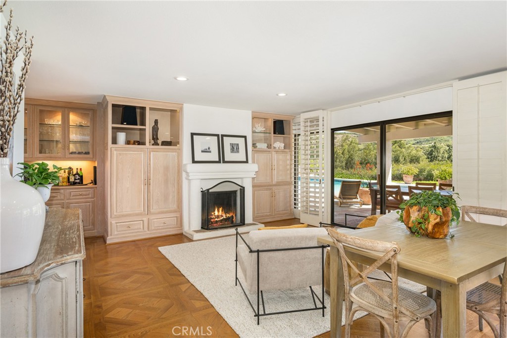 9741 Rangeview Drive North Tustin, CA 92705 - Photo 10 of 48 A gas log or wood-burning hand-trowled fireplace is the focal point of the family room which also features a built-in entertainment center (behind large doors to the left of the fireplace, two sets of sliding glass doors, plantation shutters, recessed lighting and a large bar with lighted display cabinetry.