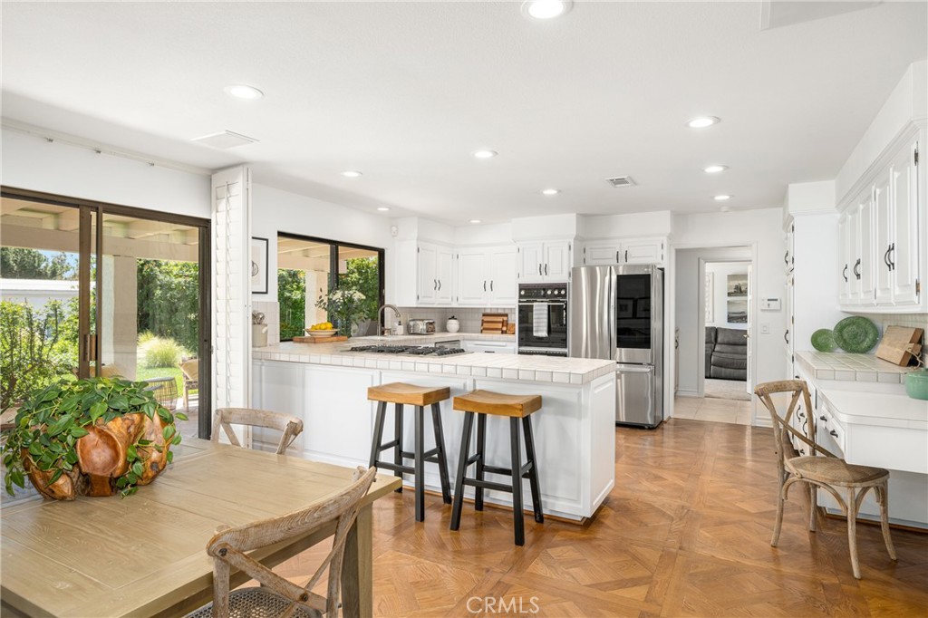 9741 Rangeview Drive North Tustin, CA 92705 - Photo 12 of 48 a kitchen with stainless steel appliances kitchen island wooden cabinets and dining table