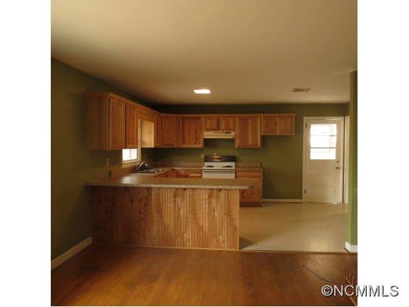 2005 Ratcliff Cove Road Waynesville, NC 28786 - Photo 3 of 20 a kitchen with stainless steel appliances granite countertop a refrigerator a stove and a sink with wooden cabinets