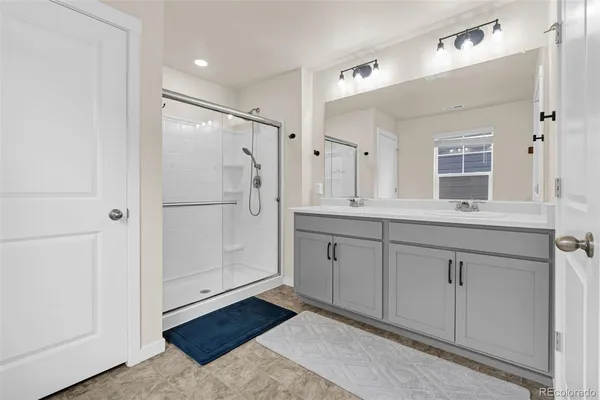 a bathroom with a granite countertop shower sink and mirror