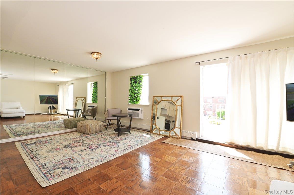 320 East Shore Road, Unit 4C Great Neck, NY 11023 - Photo 9 of 29 Living room with parquet floors, healthy amount of natural light, and a wall mounted AC