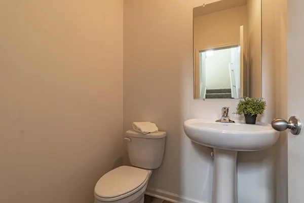 a bathroom with a toilet sink and mirror