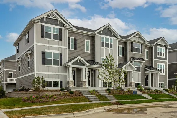 a front view of a residential apartment building with yard and parking space