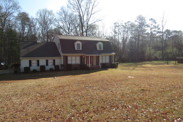 a front view of a house with yard and trees