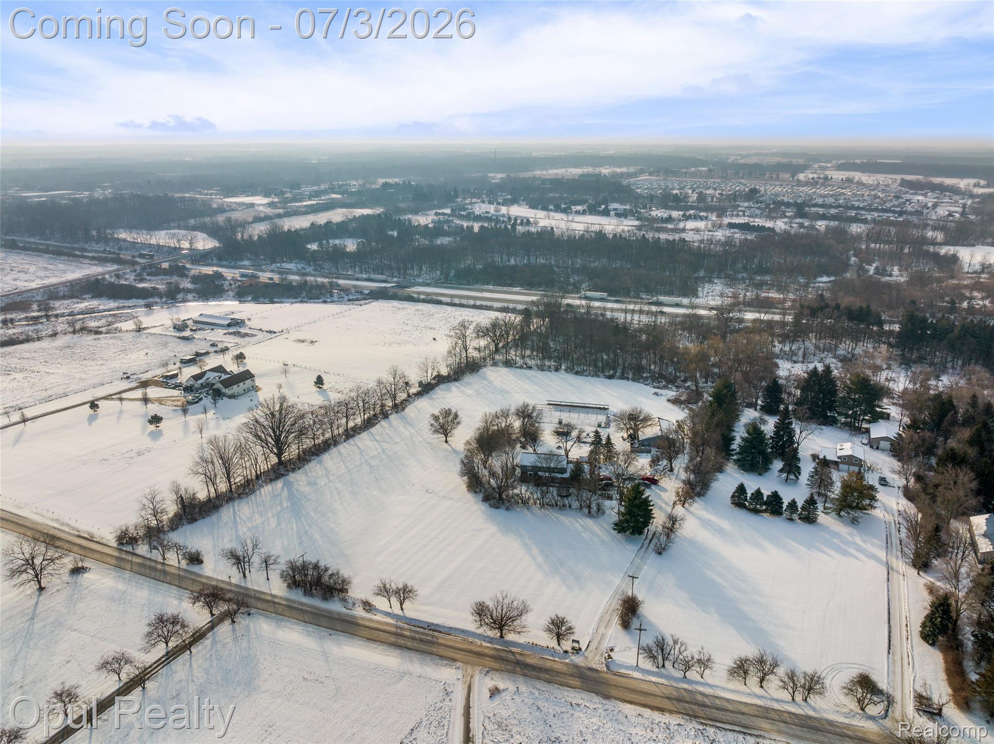 8855 Gross Road Dexter, MI 48130 - Photo 6 of 53 Expansive parcel featuring multiple outbuildings and a primary residence, bordered by mature trees and a paved roadway