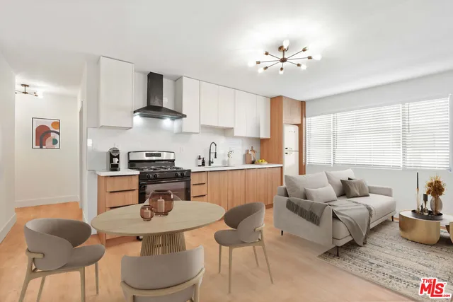 a kitchen with stainless steel appliances kitchen island granite countertop a sink a stove a dining table and chairs