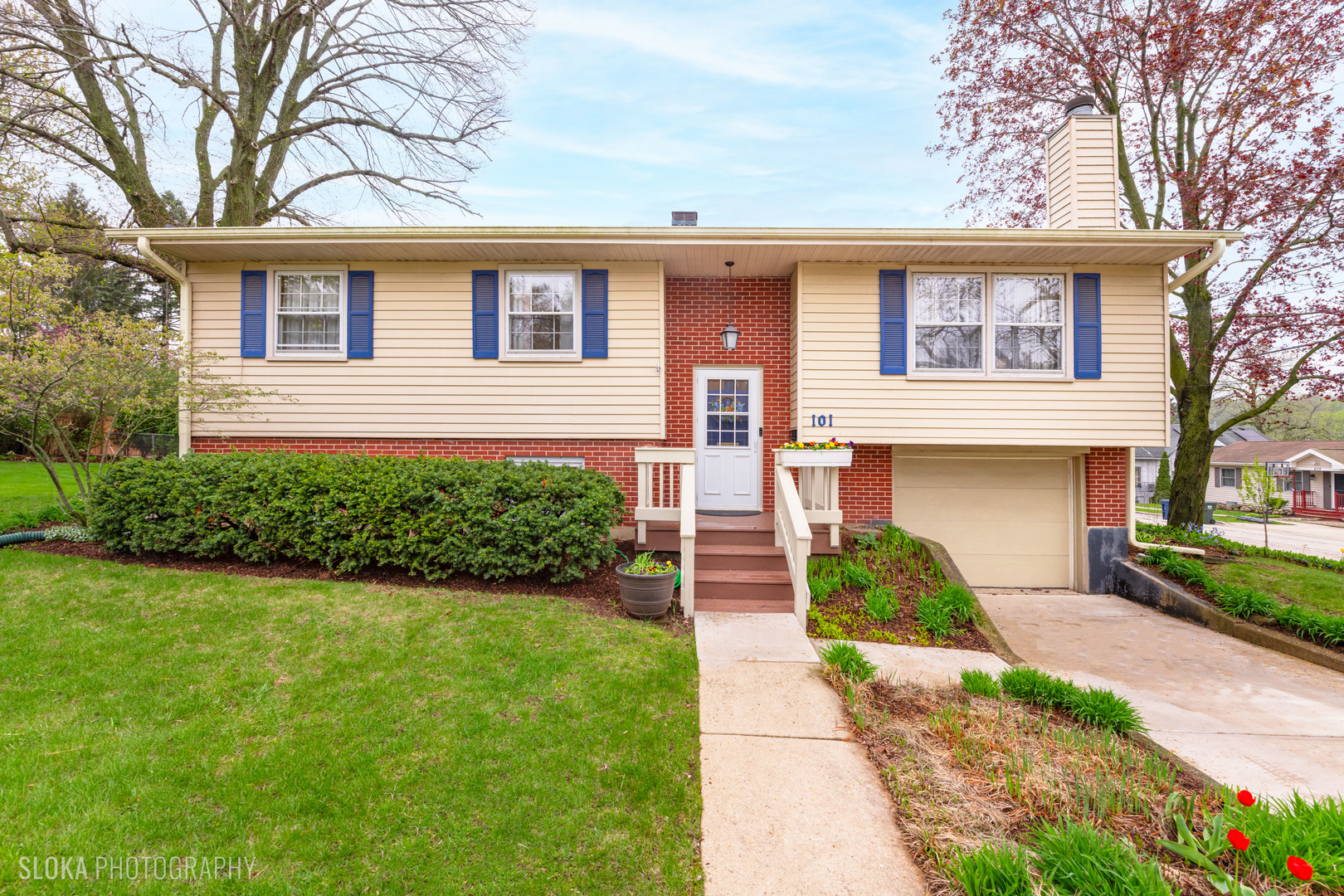 a front view of a house with a garden and yard