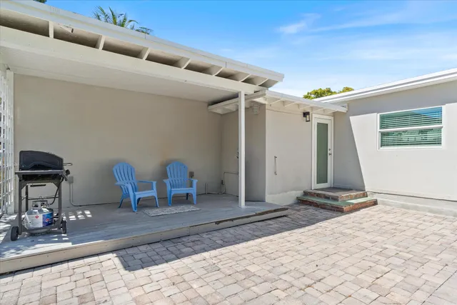 a backyard of a house with table and chairs