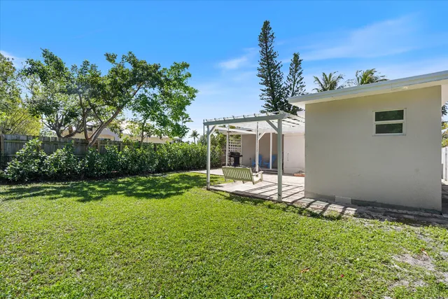 a view of backyard of house with outdoor seating and green space