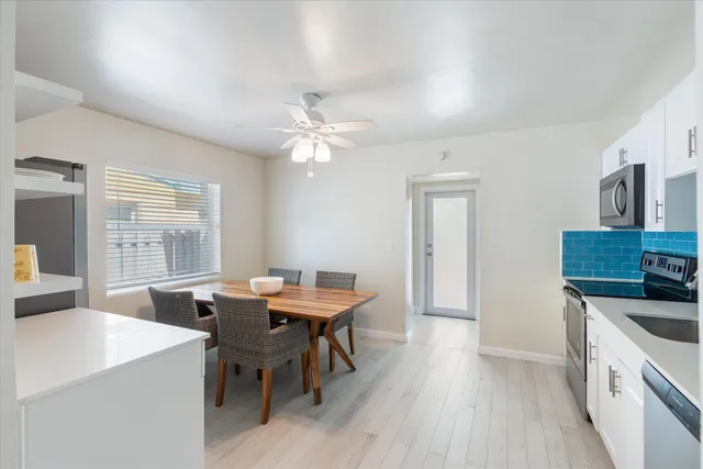 a kitchen with stainless steel appliances a table chairs and a refrigerator