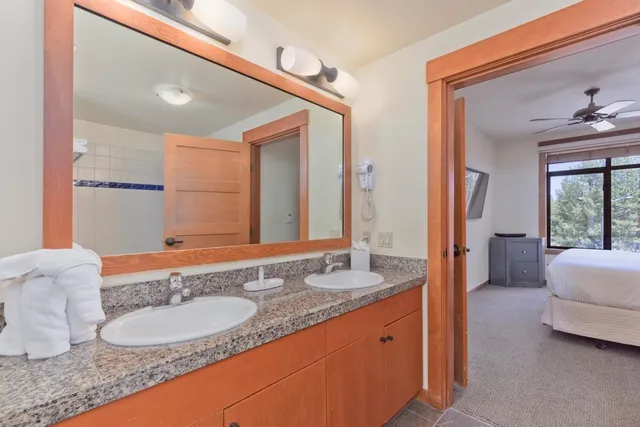 a spacious bathroom with a granite countertop sink and a mirror