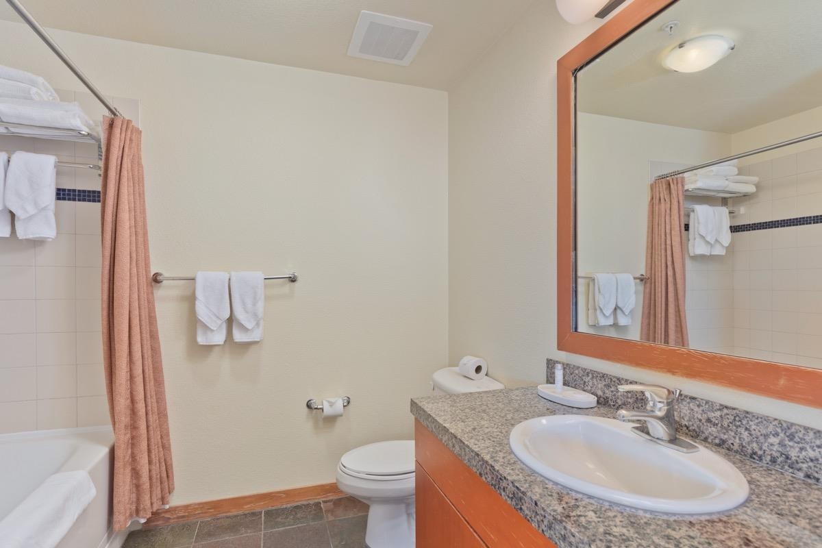 6201 Minaret Road, Unit 2215 Mammoth Lakes, CA 93546 - Photo 25 of 33 a bathroom with a granite countertop sink and a mirror