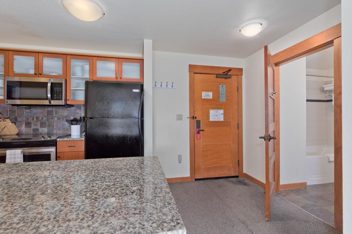 6201 Minaret Road, Unit 2215 Mammoth Lakes, CA 93546 - Photo 3 of 33 a view of a refrigerator in kitchen and an empty room