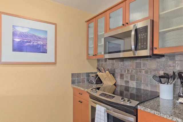 a kitchen with stainless steel appliances granite countertop a stove and a microwave
