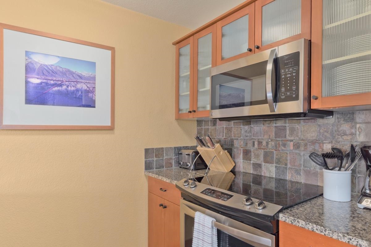 6201 Minaret Road, Unit 2215 Mammoth Lakes, CA 93546 - Photo 5 of 33 a kitchen with stainless steel appliances granite countertop a stove and a microwave