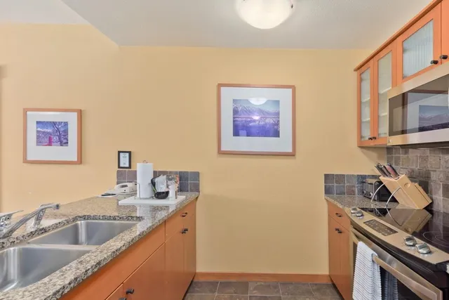a kitchen with stainless steel appliances granite countertop a sink stove and microwave