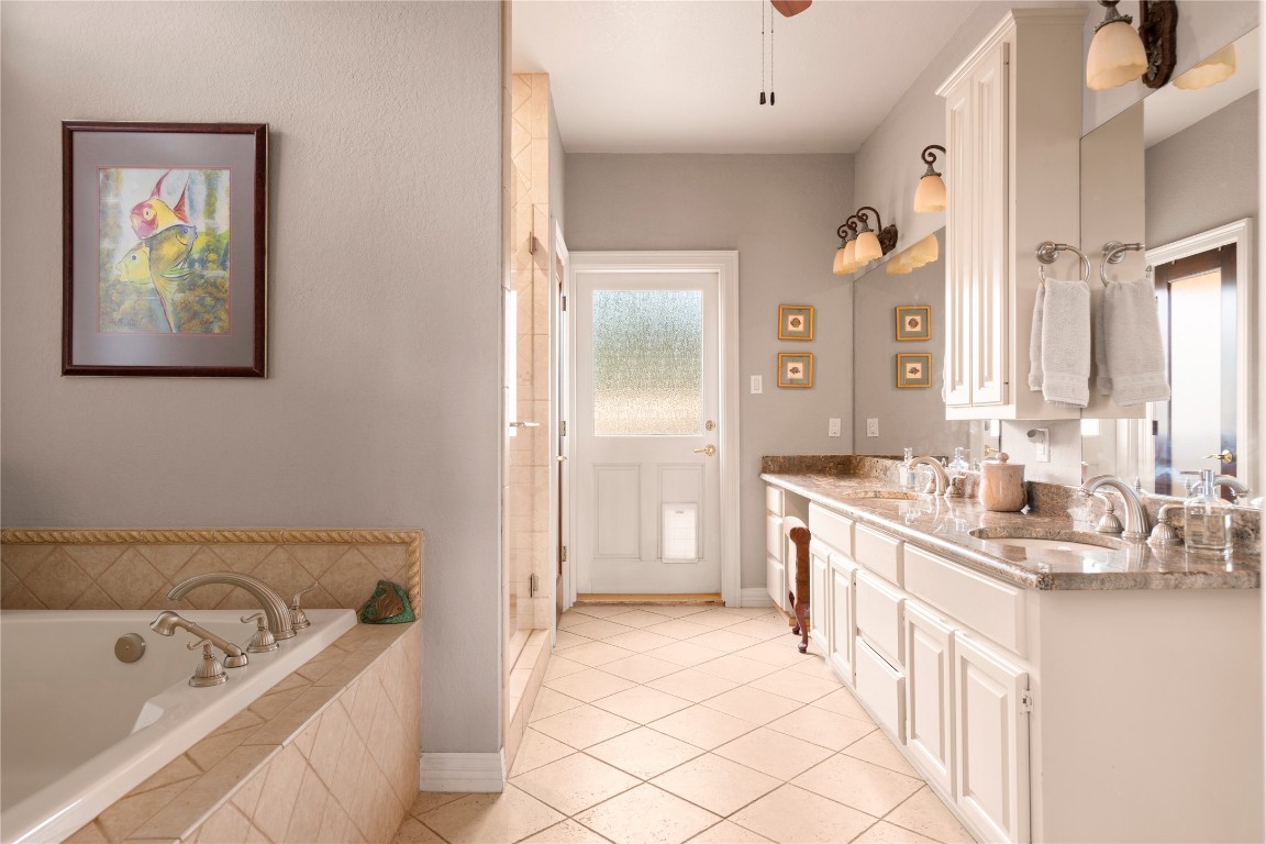 5229-5012 Hupedo Ranch Road Spicewood, TX 78669 - Photo 15 of 40 a spacious bathroom with a tub sink and mirror