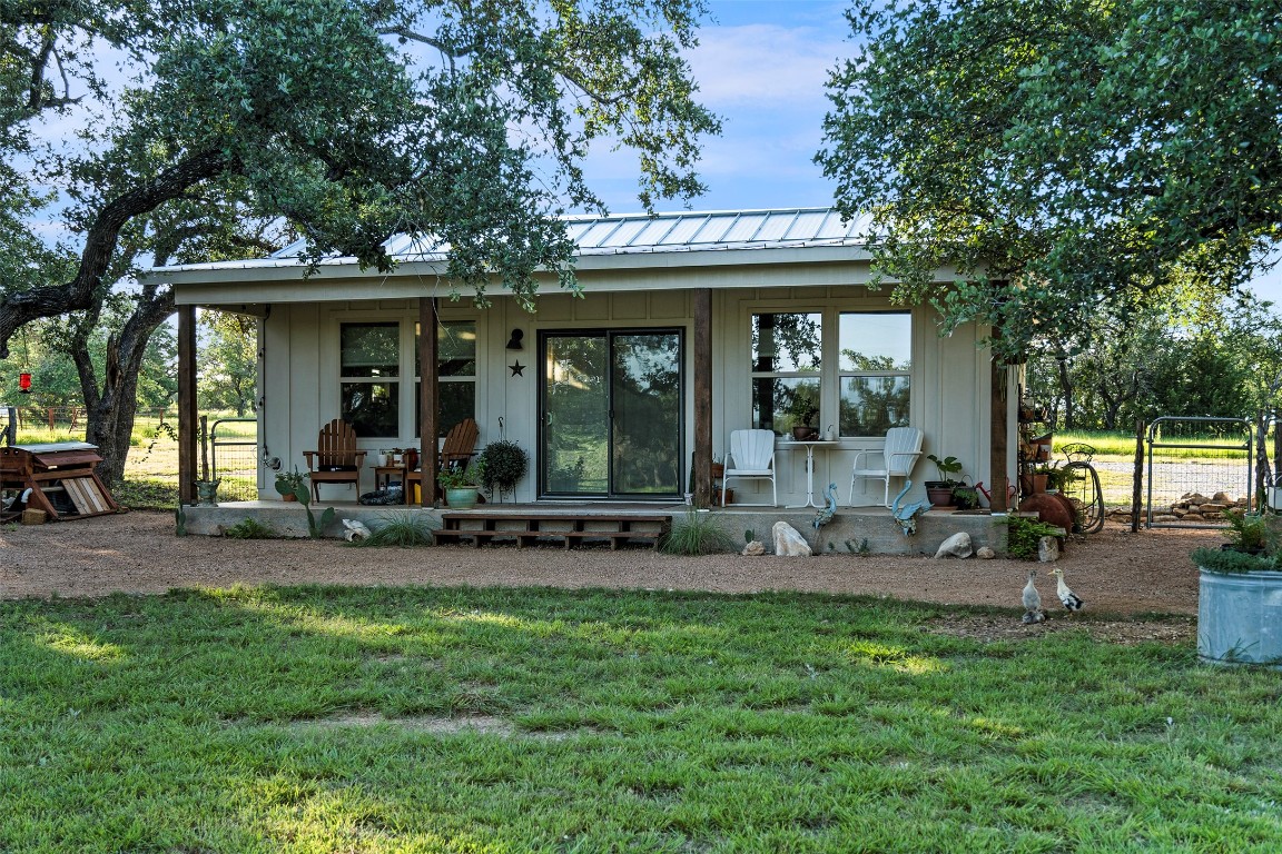 5229-5012 Hupedo Ranch Road Spicewood, TX 78669 - Photo 33 of 40 a view of a chair and tables in the back yard of the house