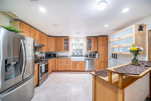 a kitchen with stainless steel appliances granite countertop a stove refrigerator sink and dishwasher